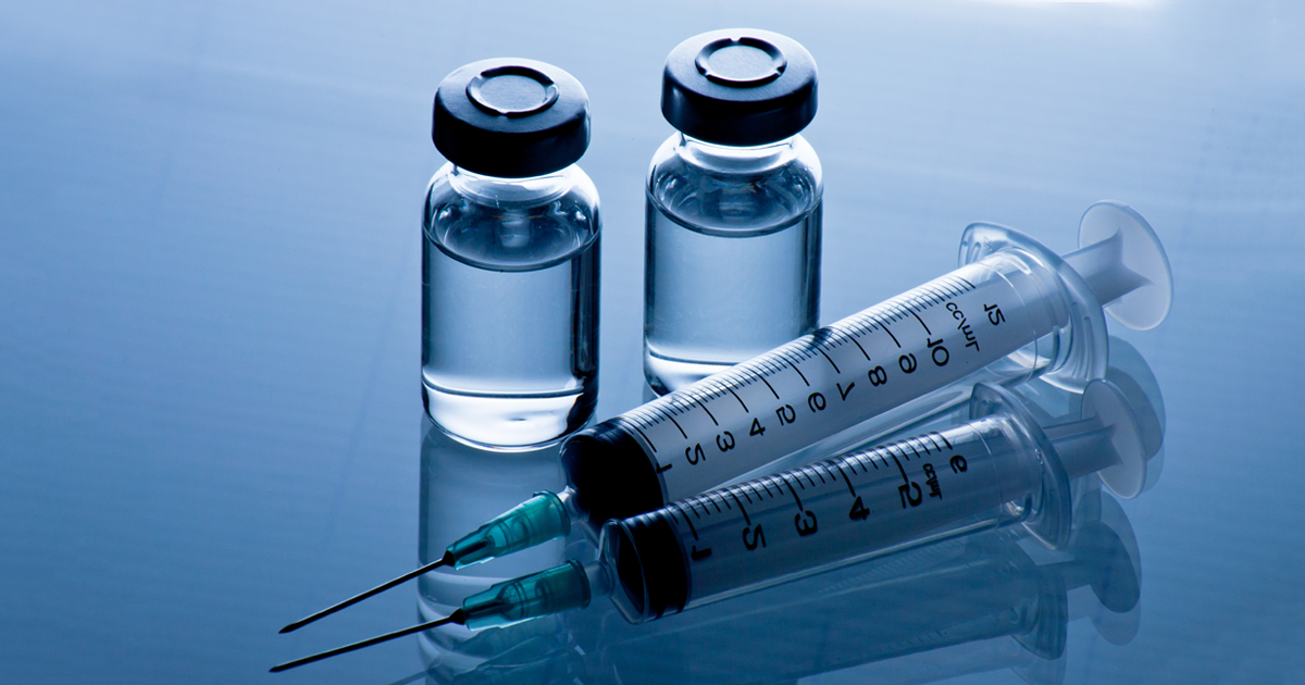 A syringe and two glass vaccine vials